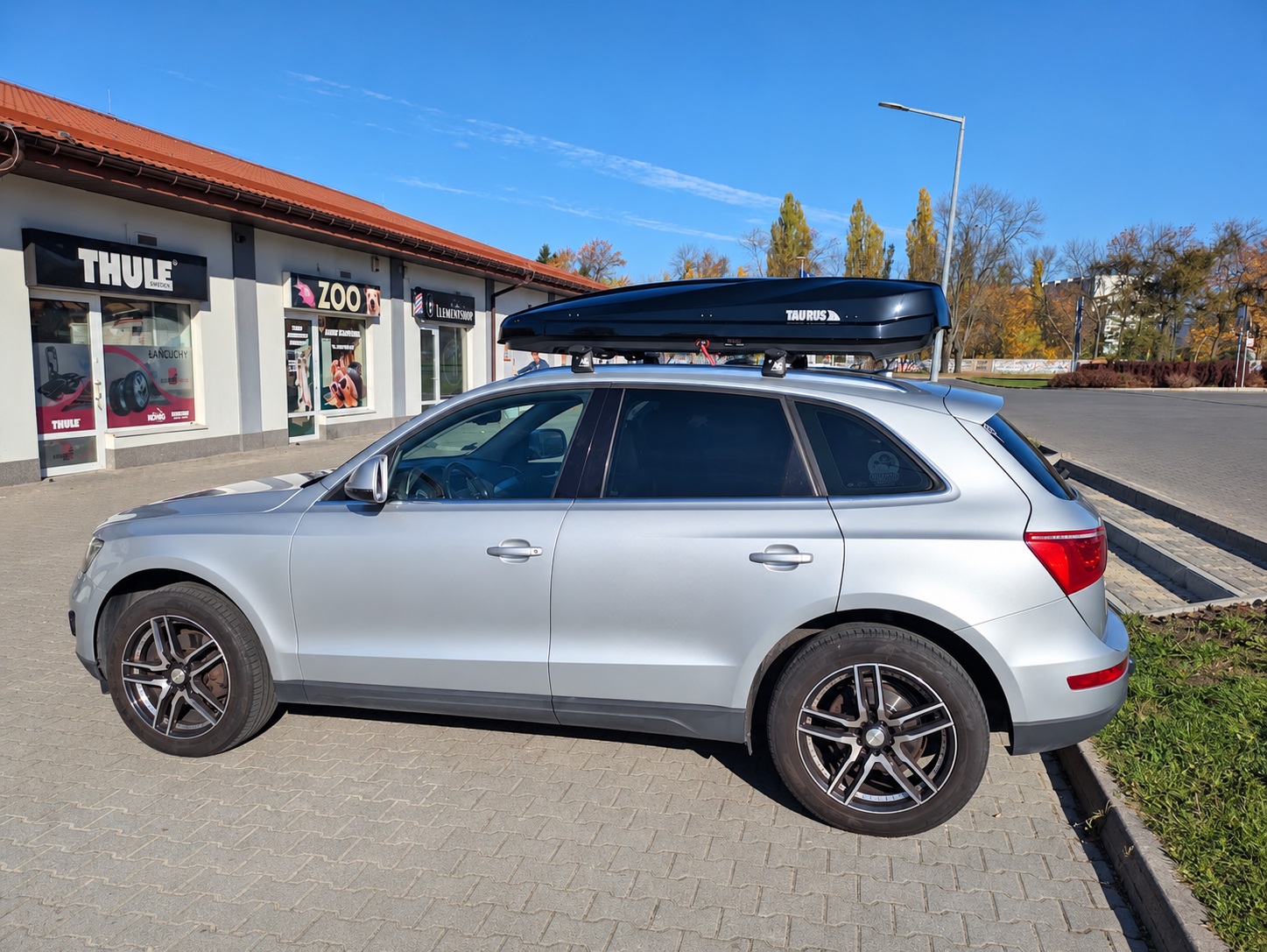 Niski profil boxa Taurus Strike 440 na dachu Audi Q5 przed salonem Boxcars